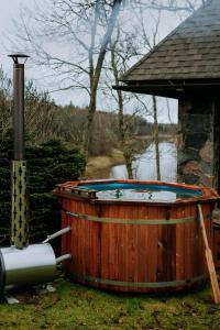 una vasca in legno con tavolo da biliardo accanto a una casa di Log Cabin a Kuldīga