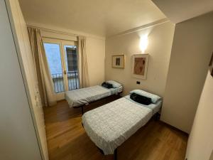 Habitación pequeña con 2 camas y ventana en CENTRO STORICO Eleganza e Lusso nel Monferrato en Casale Monferrato