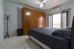 um quarto com uma cama e um armário de madeira em Casa c otima localizacao no Setor Sul - Goiania GO em Jaraguá