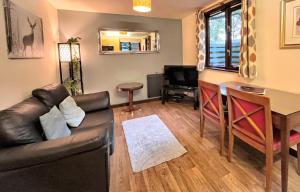 een woonkamer met een bank en een tafel bij Snug hut 5-Hot Tub-Woodland Lodges-Pembrokshire-Tenby in Carmarthen