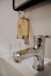 a bathroom sink with a soap dispenser next to a faucet at The Fox and Hounds in Banc-y-felin