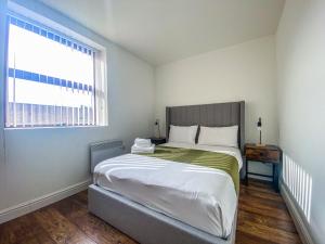 a bedroom with a large bed and a window at City Apartments by Elegance Living in Peterborough