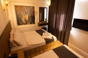 a small bedroom with a bed and a painting on the wall at GRAND İŞBİLİR HOTEL in Nevşehir