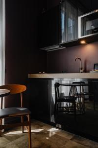 een keuken met een bar met 2 stoelen en een wastafel bij De Jonker Urban Studios & Suites in Amsterdam