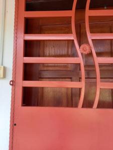 a red door with a wooden wall behind it at Bilik Transit Nilai in Nilai