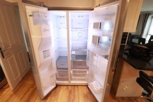 an empty refrigerator with its doors open in a kitchen at Swanwick House in Broughton