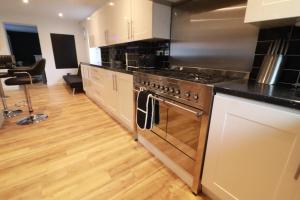 a kitchen with stainless steel appliances and a wooden floor at Swanwick House in Broughton