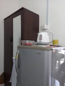 a kitchen with a microwave on top of a refrigerator at Bilik Transit Nilai in Nilai