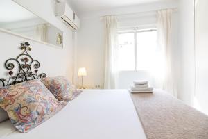 a white bedroom with a large bed and a window at Malaga Center Flat Holidays Salitre in Málaga