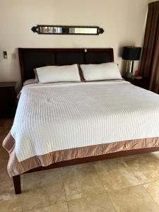 a bedroom with a large bed with white sheets at Ballena Bay Villa Lot 45 Villa del Mar in Tambor