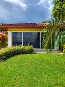 a house with a window and a green yard at Ballena Bay Villa Lot 45 Villa del Mar in Tambor