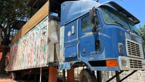 een blauwe vrachtwagen geparkeerd naast een gebouw bij Minicasa Brasileira in Sorocaba