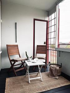 a living room with a table and two chairs at Moderni yksiö parvekkeella,, erinomainen sijainti in Helsinki