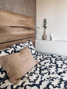 a bed with a wooden headboard and a pillow at Moderni yksiö parvekkeella,, erinomainen sijainti in Helsinki