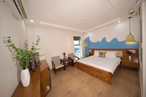 een slaapkamer met een bed en een tafel met een stoel bij Summer Beach Hotel Vung Tau in Vung Tau