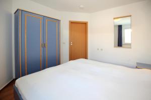 ein Schlafzimmer mit einem großen weißen Bett und einem Spiegel in der Unterkunft Yachthafenresidenz Wohnung 7303 in Kühlungsborn