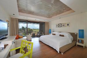 a bedroom with a large bed and a large window at Rest Detail Hotel Hua Hin in Hua Hin