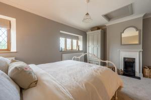 a bedroom with a bed and a fireplace at Annie's Cottage - Big Skies Holiday Cottages in Sharrington