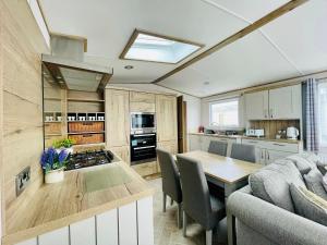 a kitchen with a table and a kitchen with a couch at Pure-Living West Sands Sunshine and Sea View - 3 Bedroom lodge at SEAL BAY in Selsey