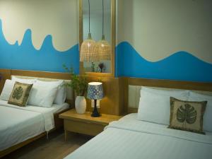 a bedroom with two beds and a blue and white wall at Summer Beach Hotel Vung Tau in Vung Tau