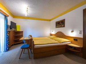 a bedroom with a bed and a desk with a computer at Gästehaus Bleiweis-Zehentner in Zell am See