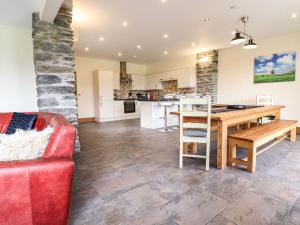a kitchen and living room with a table and a couch at The Barn in Corwen