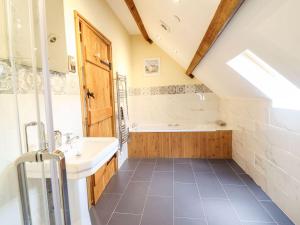 a bathroom with a sink and a bath tub at The Barn in Corwen