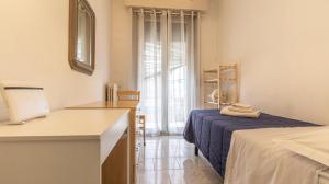 1 dormitorio con cama, escritorio y ventana en Casa della Musica - Affitti Brevi Italia, en Módena