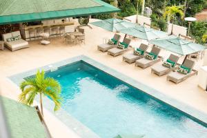 einen Blick über einen Pool mit Stühlen und Sonnenschirmen in der Unterkunft Villa do Vale Boutique Hotel in Blumenau