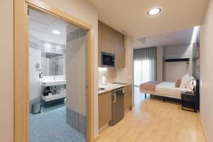 Habitación de hotel con baño con cama y lavamanos en Palau Apartments Valencia en Valencia