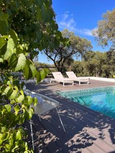 a swimming pool with two lounge chairs next to a swimming pool at Casa Dos Galegos in Marvão