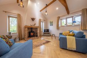 a living room with two blue couches and a fireplace at Large immaculate rural conversion - The Milking Parlour in Ipswich