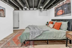 a bedroom with a large bed with orange pillows at Trendy Two-Level Apartment in Buffalo
