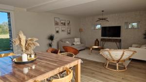 a living room with a table and chairs and a tv at Meublé 5* Au gré des saisons in La Baconnière