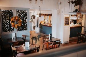 a restaurant with tables and chairs in a room at The Fox and Hounds in Banc-y-felin