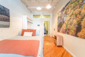 een slaapkamer met een bed en schilderijen aan de muur bij Cool Urban Stay Dtwn Apt And Patio in Binghamton