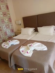 een hotelkamer met 2 bedden en handdoeken erop bij Villa Filia in Almiros strand