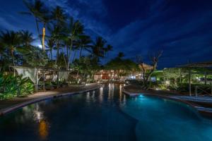 a swimming pool at night with palm trees at Vila Kalango in Jericoacoara