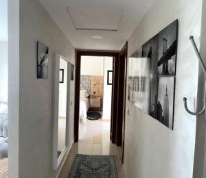 un couloir menant à une chambre aux murs blancs dans l'établissement Vague Bleue chez Makuja Home, à Bouznika
