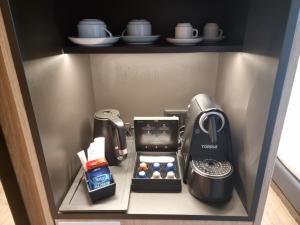 Hotel Principe Avila في لشبونة: ثلاجة صغيرة فيها آلة صنع القهوة ومحمصة
