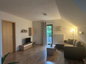 Una sala de estar con un sofá y un televisor. en Ferienwohnung Rhön Verliebt, en Abtsroda 10 fotos más