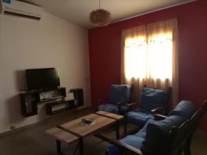 a living room with blue chairs and a table and a window at Casa Norte in La Rioja