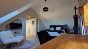 a bedroom with a bed and a table and a chair at Meublé 5* Au gré des saisons in La Baconnière