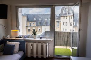 ein Wohnzimmer mit einem großen Fenster und einem Sofa in der Unterkunft Studio Lux city in Luxemburg (Stadt)