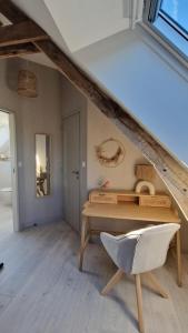 a living room with a table and a chair at Meublé 5* Au gré des saisons in La Baconnière