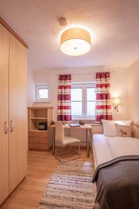 1 dormitorio con escritorio, 1 cama y 1 mesa en Patteriol Apart-Hotel-Garni en Sankt Anton am Arlberg