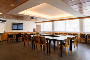 a conference room with tables and chairs and a screen at Hotel Logis Lacotel in Hossegor