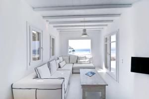 a white living room with a couch and a table at Luxury Mykonos Villa - 4 Bedrooms - Sea View & Private Pool - Elia in Elia Beach