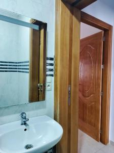 a bathroom with a sink and a mirror and a door at Oued laou beach in Oued Laou