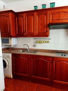 a kitchen with wooden cabinets and a sink at Casa Perla - Cerca de la playa in Playa de Santiago